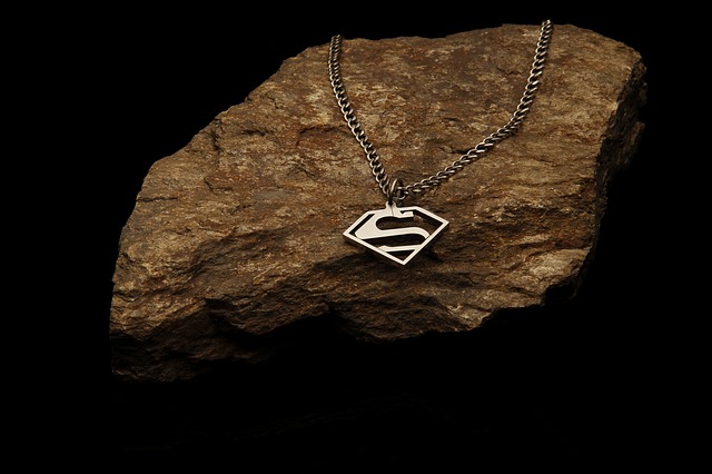 Strieborná retiazka so symbolom Superman zavesená na kameni.jpg
